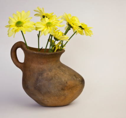 bouquet in a purple teapot. still life with garden flowers on a dark background.