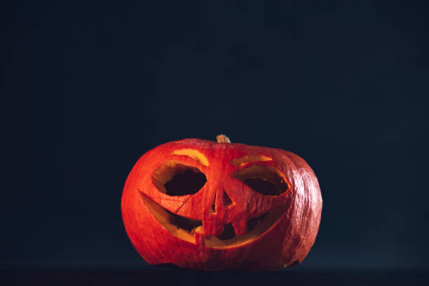istock Spooky Halloween carved pumpkin, jack o lantern, on black background 1042294038