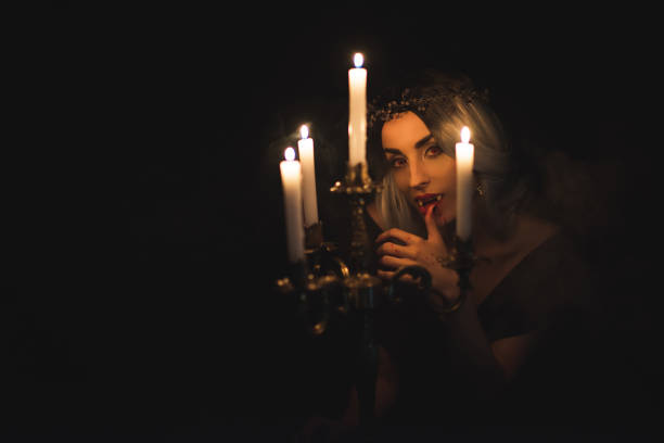 istock vampire licking her fingers isolated on black 1042295192