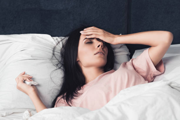 istock sick young woman with high temperature lying in bed 1042297160