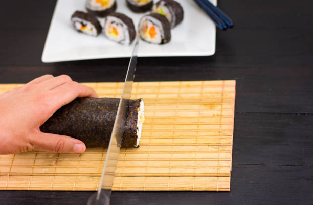 istock Woman hands cutting sushi 1042301974