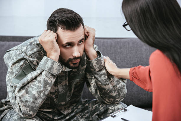 istock depressed soldier with post traumatic syndrome looking at psychiatrist during session 1042305448