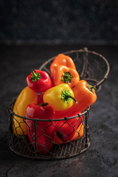 Group of colourful Sweet bell pepper in small metal becket on dark background. Top view, vertical composition. Group of colourful Sweet bell pepper in small metal becket on dark background. Top view, vertical composition. bell pepper stock pictures, royalty-free photos & images