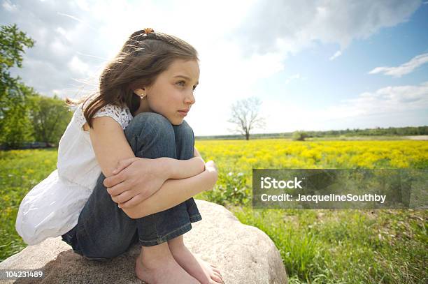 Girl Sitting On A Rock Stock Photo - Download Image Now - 8-9 Years, Agricultural Field, Flower