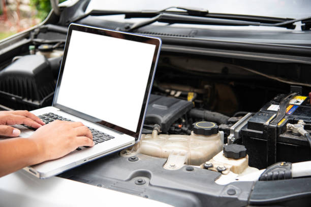 istock Professional mechanic checking car engine search for data with laptop and connect data system on car 1042315058