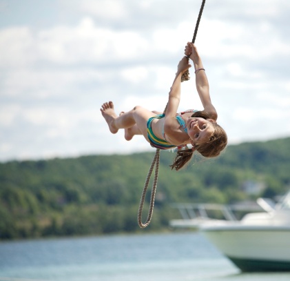 Girl on Rope Swing Over the Water