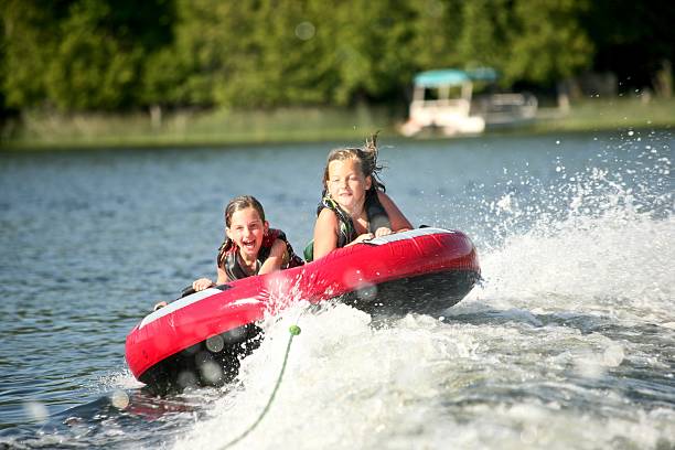 freunde tubing auf dem see - schlauch stock-fotos und bilder