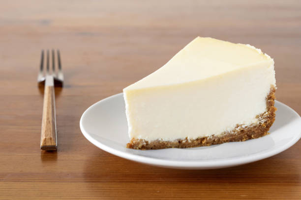 나무 테이블에 일반 뉴욕 치즈 케이크의 슬라이스 - new york 뉴스 사진 이미지