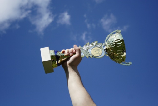 Trophy, award and target with a sports cup on an empty court outdoor for the winner, champion or victor. Gold, goal and success with a prize on the floor outside at a stadium or arena for sport