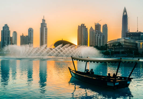 fontes de cantar em dubai. dubai promenade cantando as fontes sobre o fundo de arquitetura. dubai. no verão de 2016. - east dubai middle built structure - fotografias e filmes do acervo