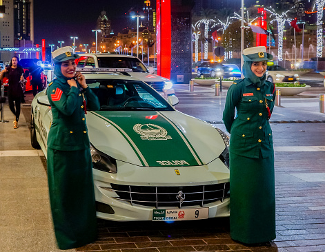 Dubai. Summer 2016. Dubai women police at the luxurious Ferrari near Dubai Mall smile. Arab woman in the modern world. Welcome Dubai