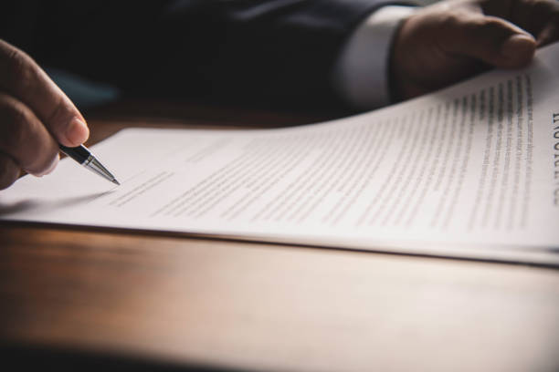 istock Hand holding pen signing contract in important documents. 1042336050