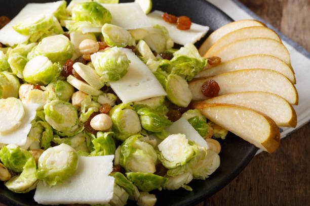 istock Healthy food: salad from Brussels sprouts, hazelnuts, cheese, raisins and pears closeup. horizontal 1042342948