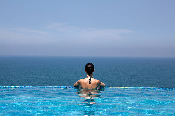 istock woman looking the sea bathing  infinity swimming  pool 104234448