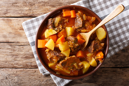 delicious stew estofado with beef and vegetables in a bowl close-up. Horizontal top view from above