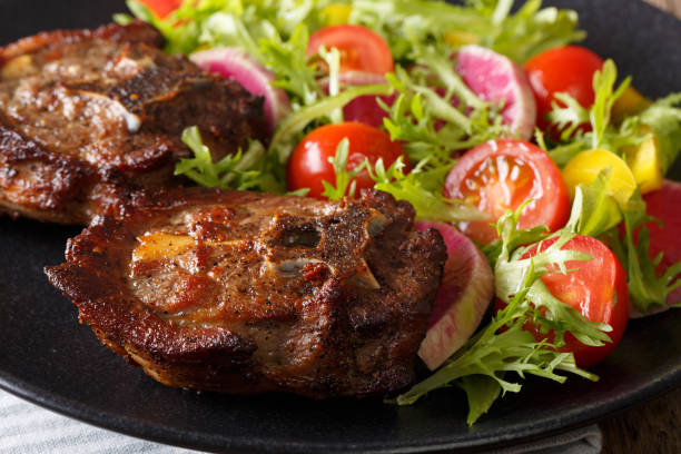 istock roasted lamb steak and fresh vegetable salad close-up. horizontal 1042350978