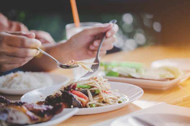 istock Close up hand is scooping the papaya salad on the table. 1042356124