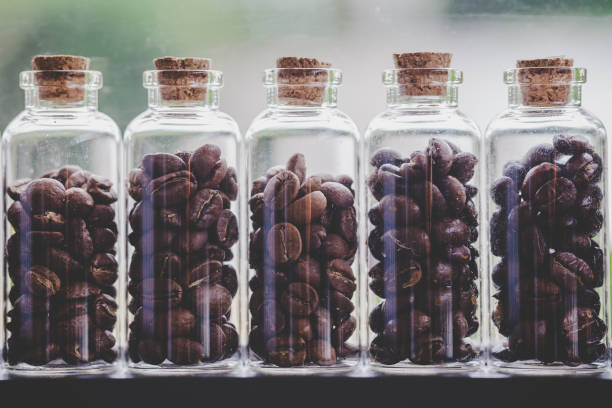 istock Close up coffee beans in glass bottles lined up in rows. 1042356128