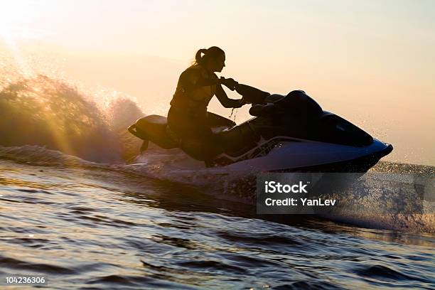 Photo libre de droit de Belle Fille Équitation Son Jet Skis banque d'images et plus d'images libres de droit de Motomarine - Motomarine, Faire du jet-ski, Coucher de soleil