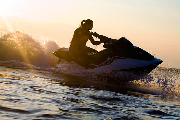 A beautiful girl riding a jet ski during sunset