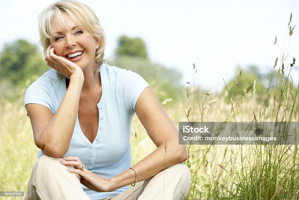 Mature woman sitting in countryside  50-59 Years Stock Photo