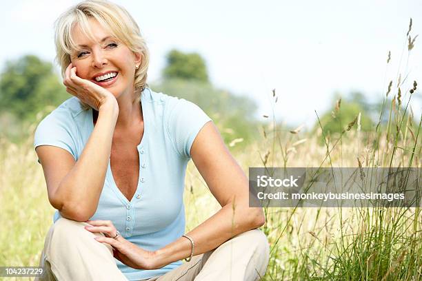 Mature Woman Sitting In Countryside Stock Photo - Download Image Now - 50-59 Years, Beautiful People, One Woman Only