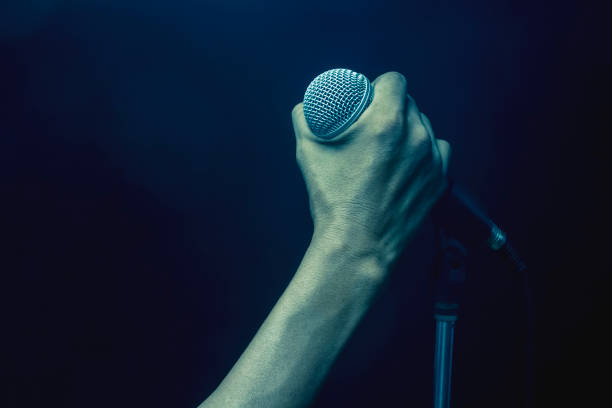 istock Men caught on a microphone on a stand. Sound Engineer Mike sound check. 1042373406