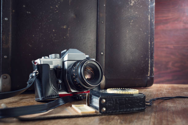 istock Vintage photo camera, light meter and suitcase on table. 1042385460