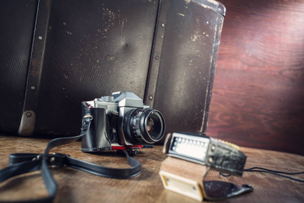 istock Vintage photo camera, light meter and suitcase on table. 1042385502