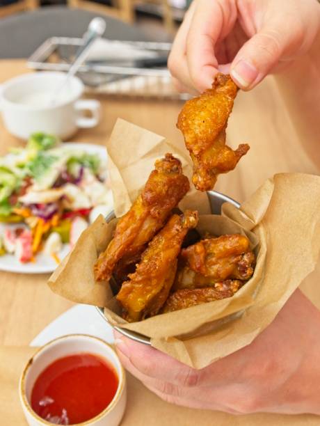 istock Picking up a fried chicken wing that put in bucket 1042385986