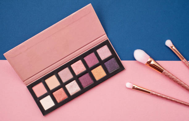 Flat lay female cosmetics collage with eye shadows and brushes on pink and blue background. Top view Flat lay female cosmetics collage with eye shadows and brushes on pink and blue background. Top view set eyeshadow stock pictures, royalty-free photos & images