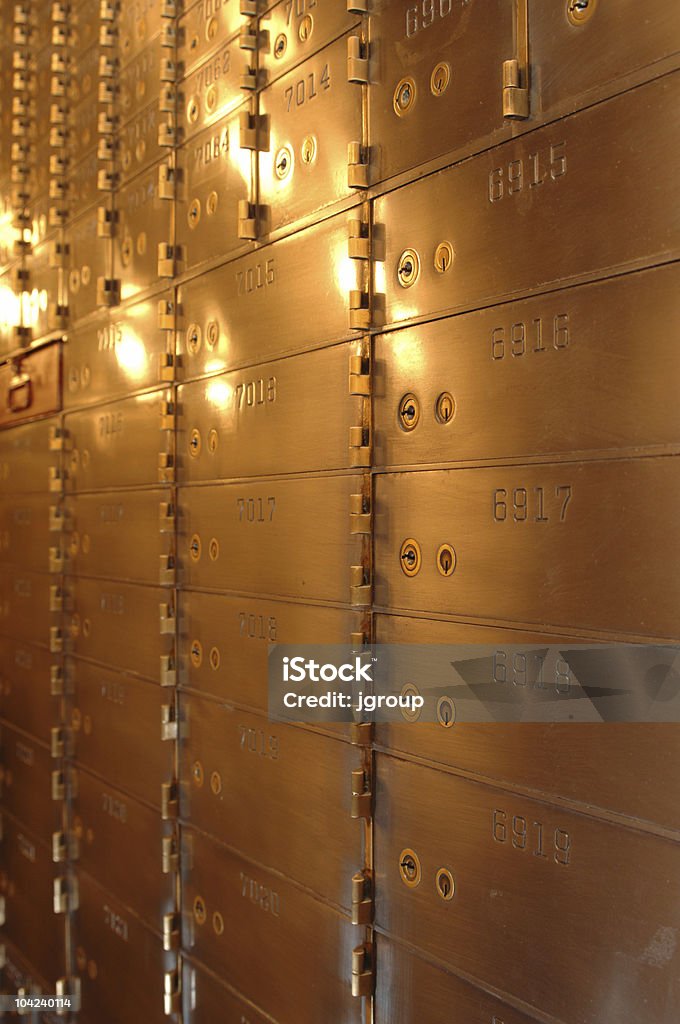 Vertical photo of safety deposit boxes in yellow light Safety deposit boxes inside a vault Bank - Financial Building Stock Photo