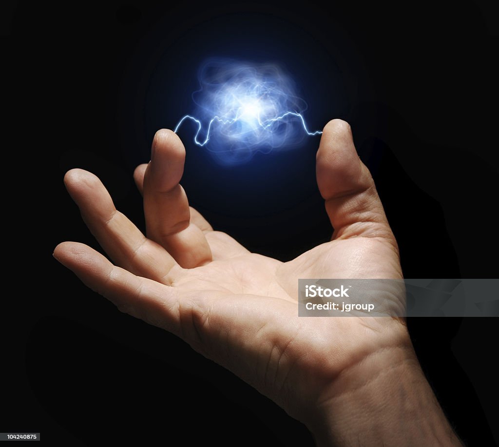 Energy male hand with electricity arcing between thumb and middle finger with plasma ball suspended in the center Electricity Stock Photo