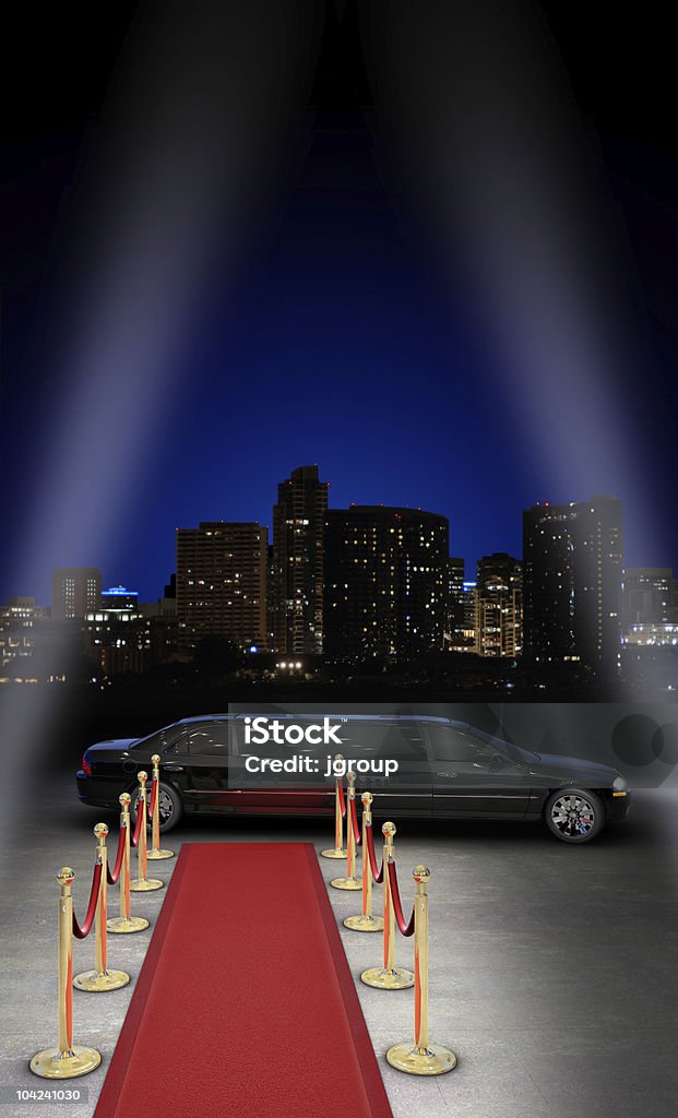 Nightlife VIP limousine parked in front of a red carpet with a city skyline in the background and searchlight beams coming in from the side Red Carpet Event Stock Photo