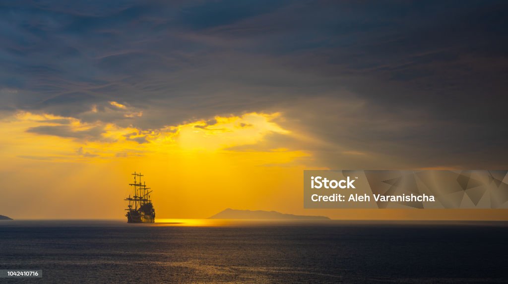 Pirate ship at the open sea Pirate ship at the open sea at the sunset Old Stock Photo