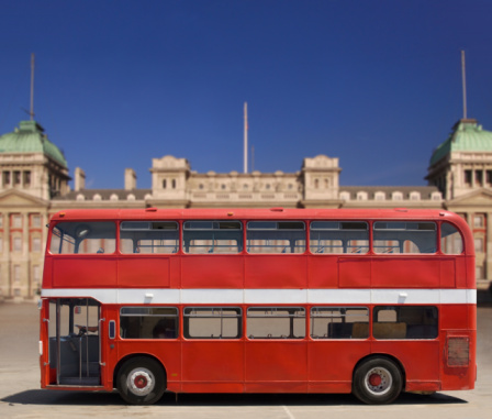 Vintage, red double decker British bus in front of Buckingham Palace, isolated with clipping path