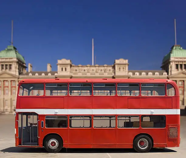 Photo of A empty red double decker bus in front of a building