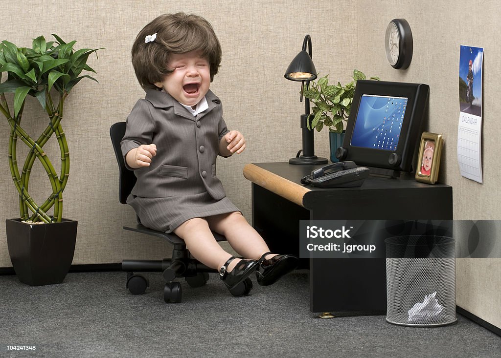 Office Babe Baby dressed in professional office attire crying at her desk Humor Stock Photo