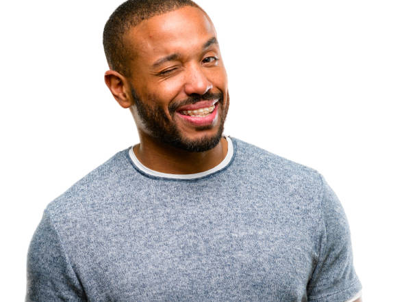 istock African american man with beard blinking eyes with happy gesture 1042414272