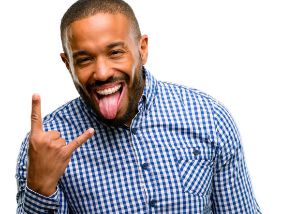 istock African american man with beard making rock symbol with hands, shouting and celebrating with tongue out 1042414624