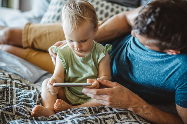istock Father shows little daughter something on phone 1042416374