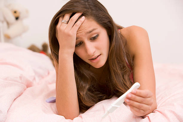 nastolatka, leżącego na swoim łóżku z test ciążowy - teenage pregnancy obrazy zdjęcia i obrazy z banku zdjęć