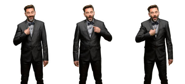 istock Middle age man, with beard and bow tie happy and surprised cheering expressing wow gesture, pointing with finger 1042418492