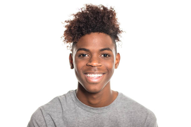 Portrait of happy teenage african boy Portrait of happy teenage african boy wearing a t-shirt. Smiling male teenager against white background. smiling kids on white stock pictures, royalty-free photos & images