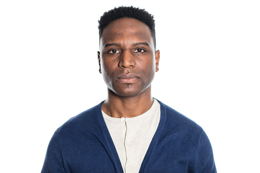 Portrait of mature african man against white background. Male model in casuals looking at camera with serious expression.
