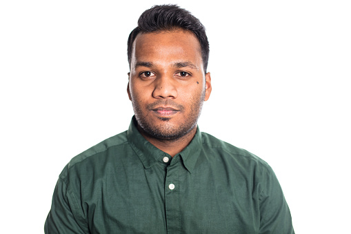 Portrait of young Indian man staring at camera. Male in in shirt on white background.