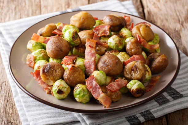 istock Delicious appetizer: roasted chestnuts, Brussels sprouts and bacon close-up. horizontal 1042419810