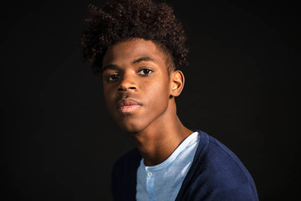 Teenager with afro hair style Close-up portrait of confident young man in casuals looking at camera. Teenager with afro hair on black background. contemplation photos stock pictures, royalty-free photos & images