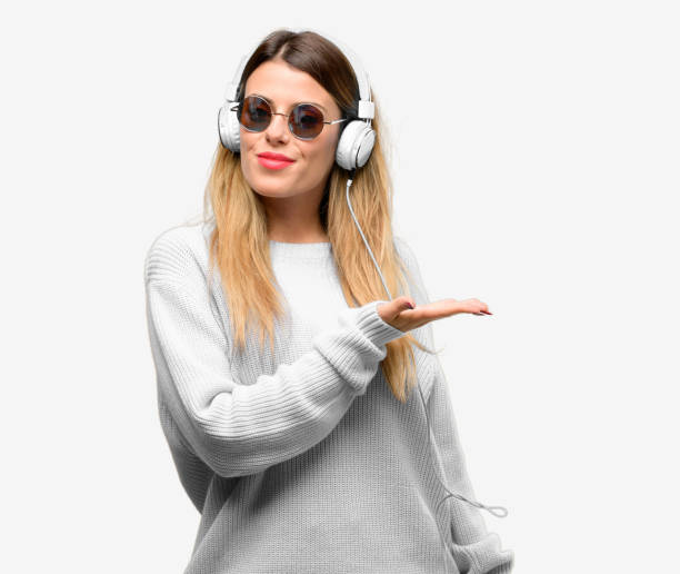 istock Young woman listen to music with headphone holding something in empty hand 1042424708