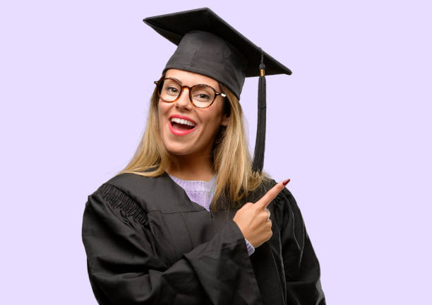 istock Young woman university graduate student pointing away side with finger 1042425232